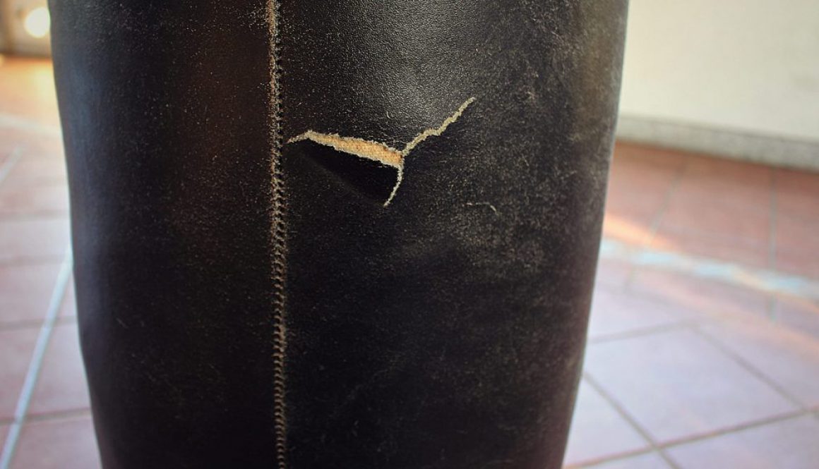 Zoom on a detail of a black professional boxing / punching bag broken